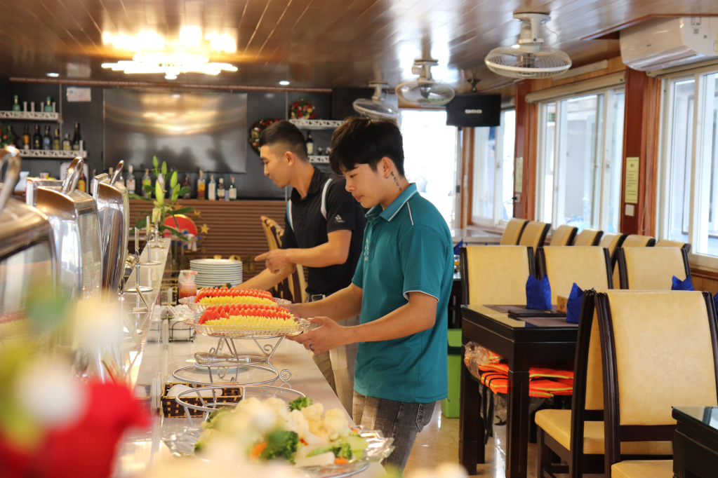 Nhân viên trên tàu tham quan Vịnh Hạ Long chuẩn bị đồ ăn đón khách. 