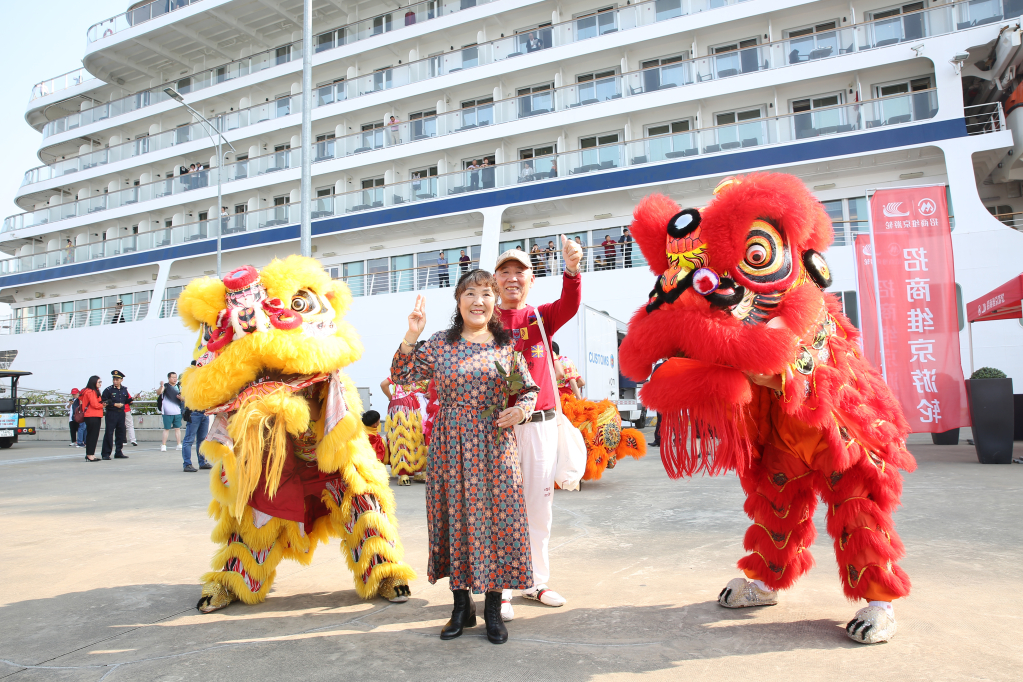 Du khách Trung Quốc thích thú chụp ảnh lưu niệm cùng màn múa lân.